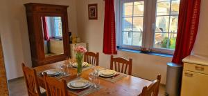 a dining room table with a vase of flowers on it at Gîte Le Vieux Sart de Sprimont in Sprimont