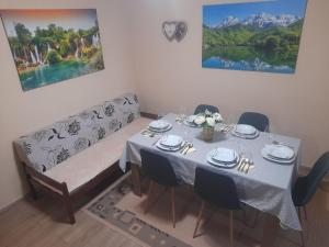 a dining room with a table and a couch at Apartment Classic Plus in Bivolje Brdo