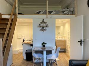 a room with a table and two chairs and a loft at Appartement Rozay en brie in Rozay-en-Brie