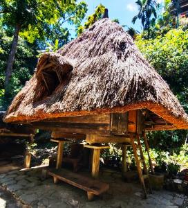 una choza con techo de paja sobre un soporte en Batad Pension and Restaurant Native House, en Banaue