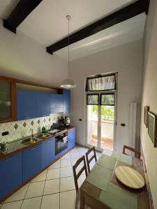 eine Küche mit blauen Schränken und einem Tisch mit Stühlen in der Unterkunft Casa MaVi in Neapel