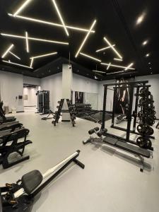 a gym with several treadmills and exercise machines at Cozy Studio Apartment in Dubai