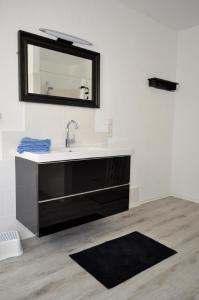ein Bad mit einem Waschbecken und einem Spiegel in der Unterkunft Ferienhaus Mosel in Löf