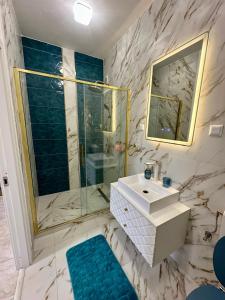 a bathroom with a sink and a glass shower at Central View Apartment in Turda +5 photos