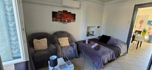 Una sala de estar con dos sillas y un sofá. en Appartement avec jardin à Colmar, en Colmar