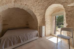 a bedroom with a bed in a stone wall at Trulli DaMì in Ceglie Messapica
