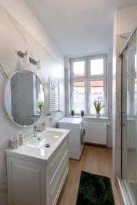 a white bathroom with a sink and a mirror at Evita7 in Gniezno