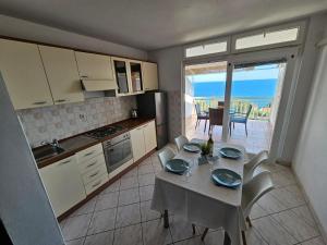 a kitchen with a table and a kitchen with a view at Apartments Sea and Pine in Ivan Dolac