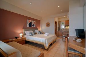a hotel room with a bed and a television at Anatoli Apartments in Agia Pelagia