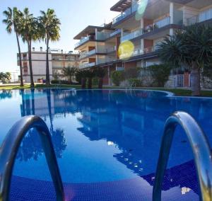 einem Pool mit blauem Wasser vor einem Gebäude in der Unterkunft Albatros Apartment met-golf-beach in Oliva