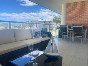 ein Wohnzimmer mit einer Couch und Weingläsern auf einem Balkon in der Unterkunft Albatros Apartment met-golf-beach in Oliva