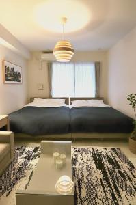 Un dormitorio con una cama grande y una ventana grande. en Generous Forest 101, en Tokio