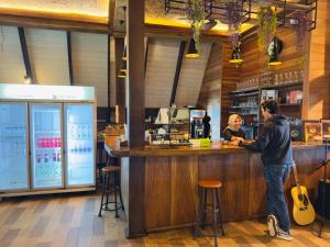 a man standing at a counter in a bar at Telaga Warna in Tengahgirang
