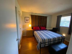 - une petite chambre avec un lit et des oreillers rouges dans l'établissement Econoroom Hollywood, à Hollywood