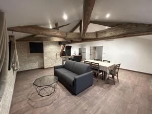 a living room with a couch and a table at Le Clos des Cadots - Apt 2ème Sud in Chaintré