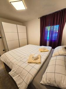 a bedroom with two beds with towels and a window at Stressless Nin in Nin