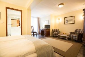 a hotel room with a bed and a living room at Schökel´s Hotel und Restaurant in Elze +33 photos
