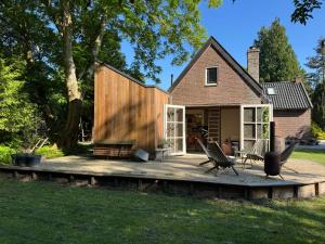 a house with a wooden deck in the yard at Zaadlab Voormalig KI station in Heerenveen