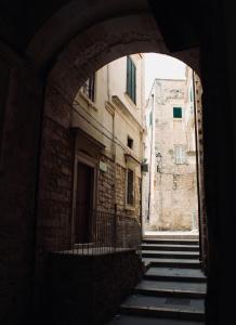 an archway in a building with stairs in an alley at Maison al Duomo in Vieste