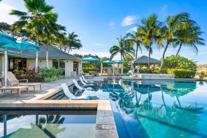 a swimming pool with chairs and palm trees at Big Island Waiulaula at Mauna Kea J201 by Coldwell Banker Island Vacations in Hapuna Beach