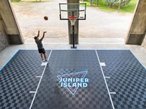 een man die een basketbal in een basketbalring dunkt bij Private Island Fire Pit & Arcade in Rigby