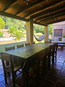 a large wooden table and chairs on a patio at Casa de Categoría con Losa Radiante en Embalsina, Villa del Dique, Calamuchita, Córdoba in Villa del Dique