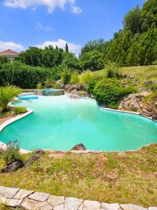 a large pool of blue water in a garden at Casa de Categoría con Losa Radiante en Embalsina, Villa del Dique, Calamuchita, Córdoba in Villa del Dique
