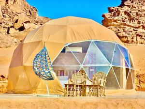 a dome tent with chairs and tables in the desert at Wadi rum camp hamod in Wadi Rum