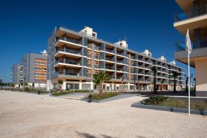 a large apartment building on the beach with a flag at Real Marina Residence in Olhão