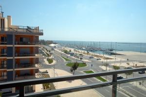 Vistas a una calle con un edificio y al océano en Real Marina Residence en Olhão