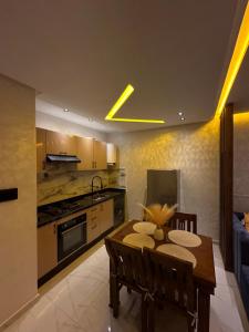 a kitchen and dining room with a table and a couch at Appartement lumineux, tout confort à deux pas de la plage de Mehdia in Plage de Mehdia
