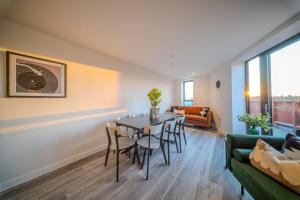 a living room with a table and chairs and a couch at Luxury 3BR Apt Sleeps 10, Wembley & Park Views in Preston