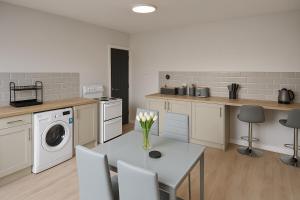 a kitchen with a table and a washing machine at Modern 3 bed duplex apartment in Central Station