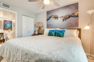 una camera da letto con un grande letto bianco con cuscini blu di Pool Access Beachfront Condo in Cape Canaveral! a Cape Canaveral Altre 17 foto