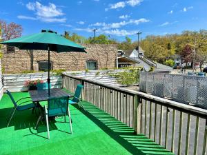 a patio with a table and chairs and an umbrella at Downtown, Roof Deck, Parking in Saugatuck