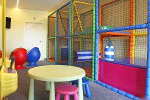 una sala de juegos con mesa y taburetes en Ara Dune Hotel en De Panne