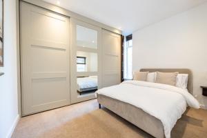 マンチェスターにあるLuxury City Centre Apartmentのベッドとガラスの引き戸のある寝室