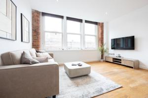 マンチェスターにあるLuxury City Centre Apartmentのソファとテレビのあるリビングルーム