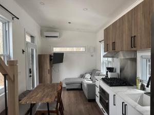 a kitchen and living room with a table and a couch at Le Grand Héron - Mini-maison à St-Zénon in Saint Zenon