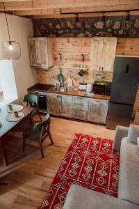 a kitchen with wooden cabinets and a red rug at Arhetip, Kikina Villa in Njegovuđa