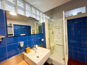 a blue bathroom with a sink and a shower at Centro Jesi Elegant Apartment in Iesi +9 photos