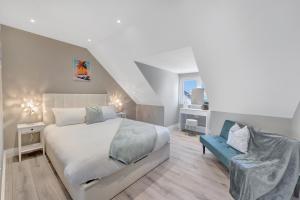 a bedroom with a bed and a blue chair at Travard at Heathrow 386a in Harmondsworth