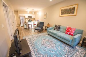 a living room with a blue couch and a television at Unit 23 Comfy 1BR Apartment Long-term stays in Chelsea