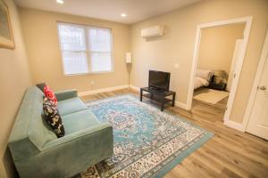 a living room with a couch and a television at Unit 23 Comfy 1BR Apartment Long-term stays in Chelsea