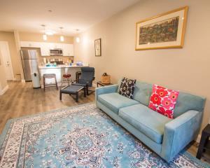 a living room with a blue couch and a kitchen at Unit 23 Comfy 1BR Apartment Long-term stays in Chelsea +12 photos