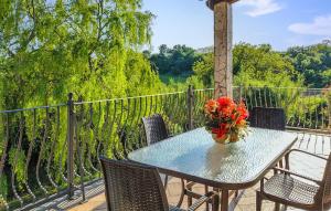 una mesa con sillas y un jarrón de flores en el balcón en Beautiful Home In Piansano Vt, en Piansano