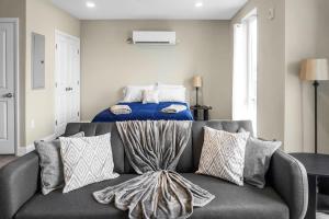 un sofá con almohadas en una sala de estar con una cama en Unit 26 Chic Studio in Chelsea, en Chelsea