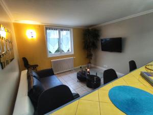 a living room with a table and chairs and a television at Location dans les Landes et le Pays basque in Labenne