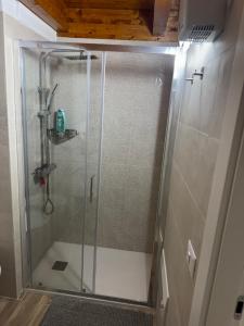 una doccia con una porta in vetro in un bagno di B&C locazione turistica a Bernalda