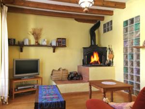 a living room with a fireplace and a tv at Casa Chaparrete in Deza